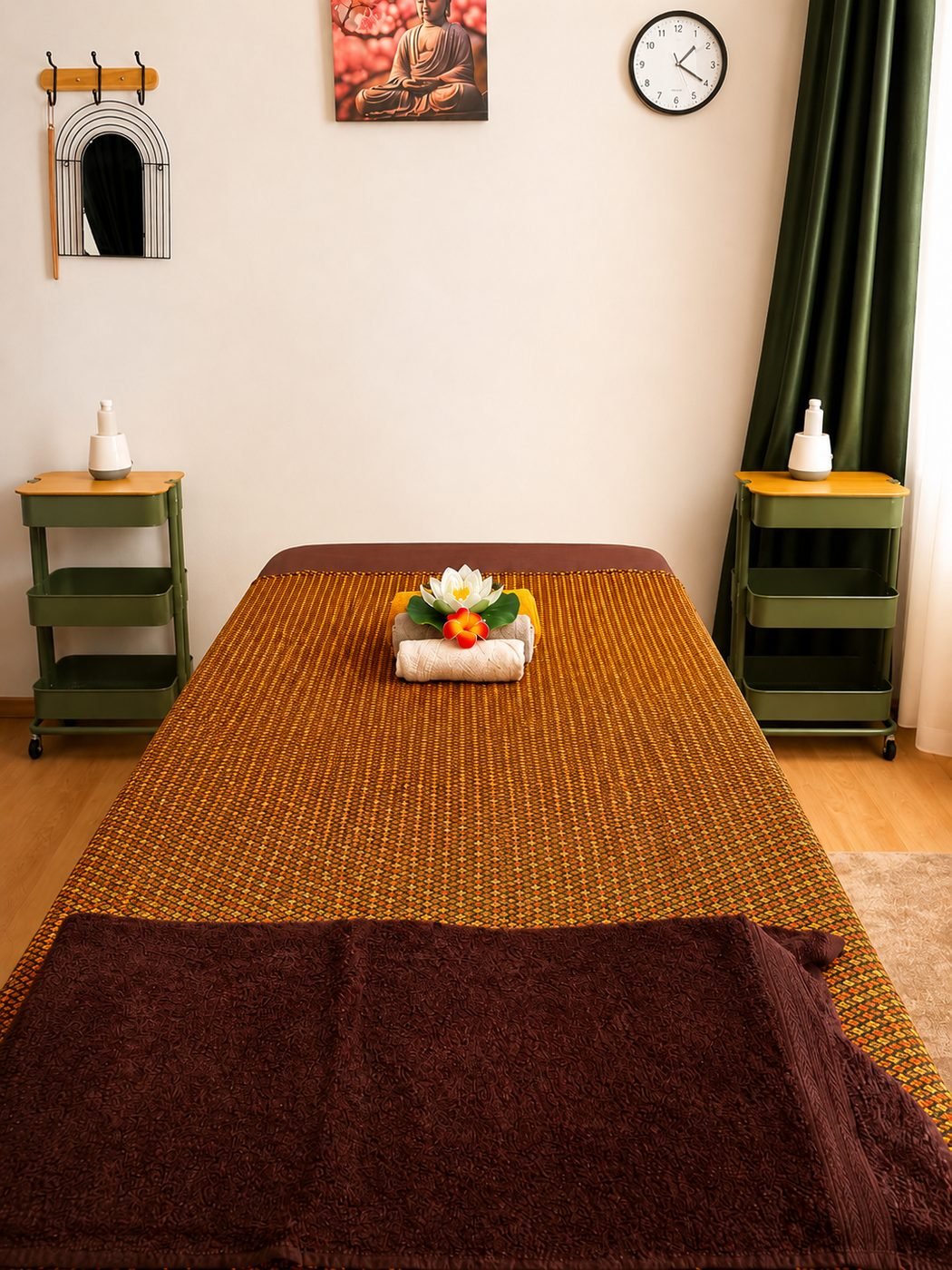Massageliege mit traditioneller Thai-Decke und frischer Blüte
